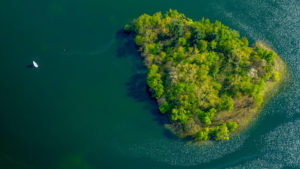 Boot auf grünem Unterbacher See mit Insel